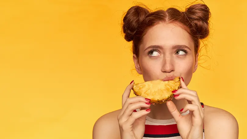 Una imagen de una mujer comiendo una piña