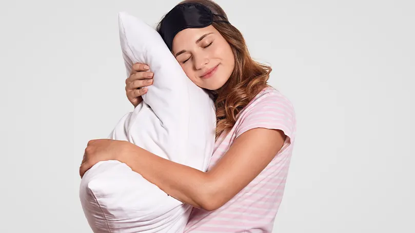 Una imagen de una mujer abrazando su almohada