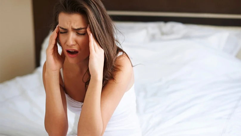 an image of a woman having a headache due to teeth grinding