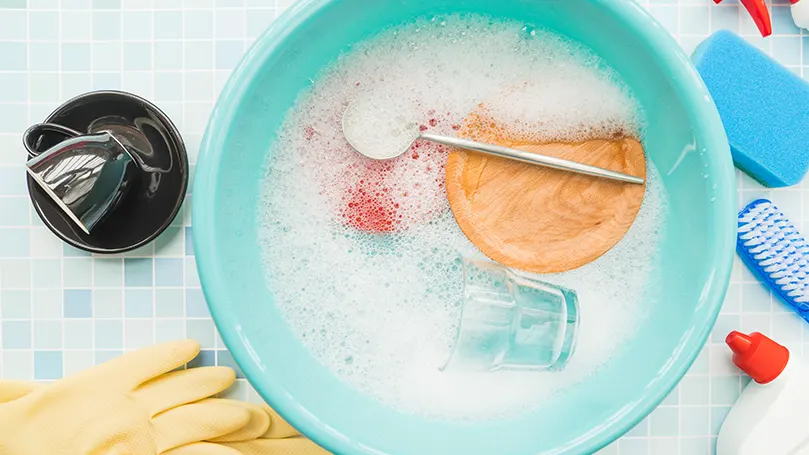 Una imagen de diferentes productos de limpieza sumergidos en agua jabonosa