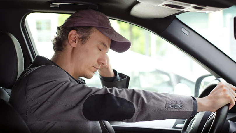 una imagen de un hombre durmiendo en su coche