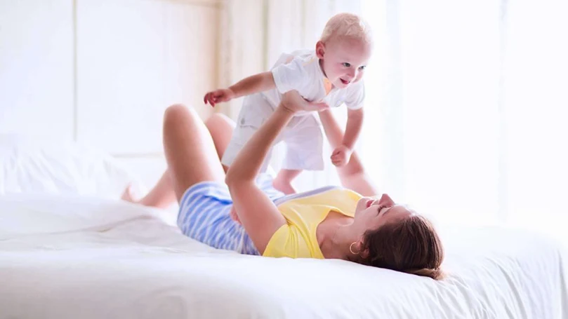 una imagen de una mamá jugando con su bebé