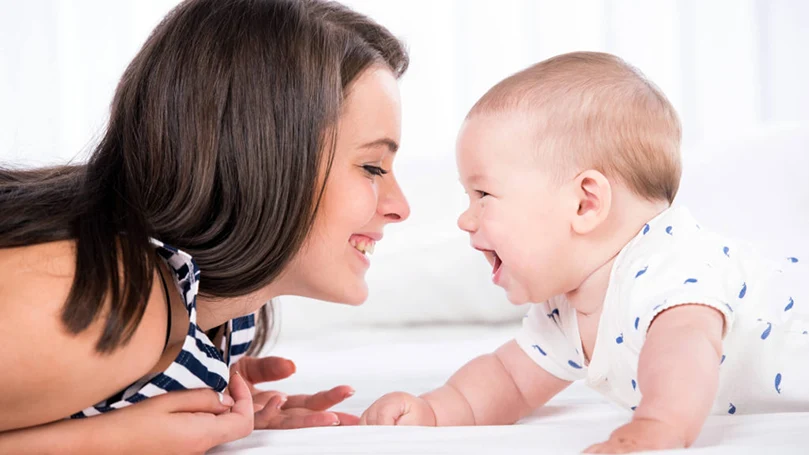 an image of a mother playing with a baby