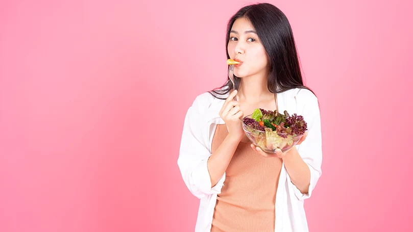 una imagen de una mujer comiendo alimentos sanos antes de acostarse