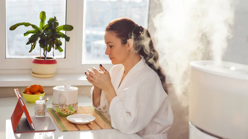 una imagen de una mujer sentada junto a un humidificador