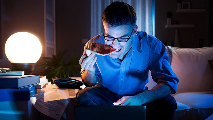 un hombre trabajando en un portátil a altas horas de la noche en la oscuridad