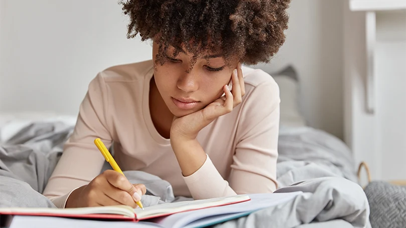 Imagen de una mujer escribiendo sus sueños en un diario onírico