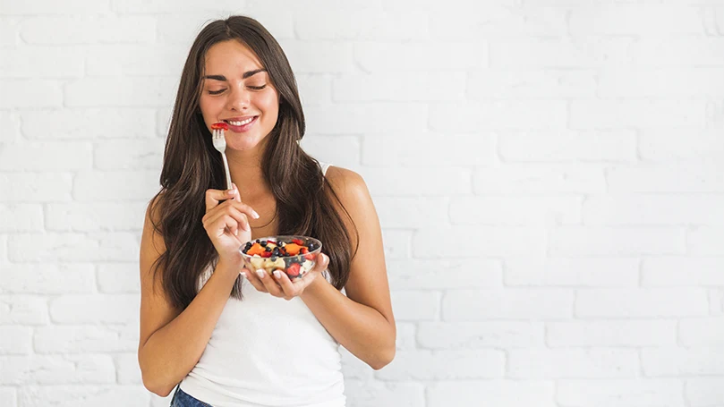 una imagen de una joven comiendo alimentos sanos para recordar los sueños