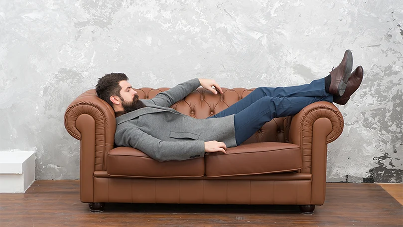 Imagen de un hombre durmiendo la siesta en un sofá.