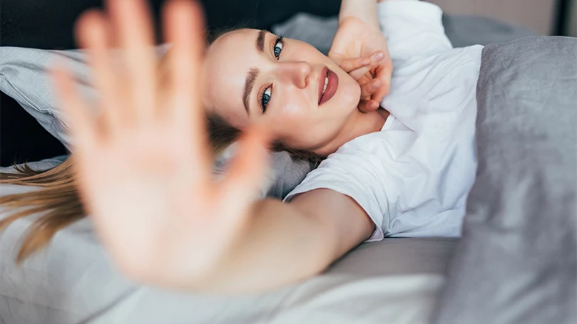 An image of a young lady stretching and staying awake .