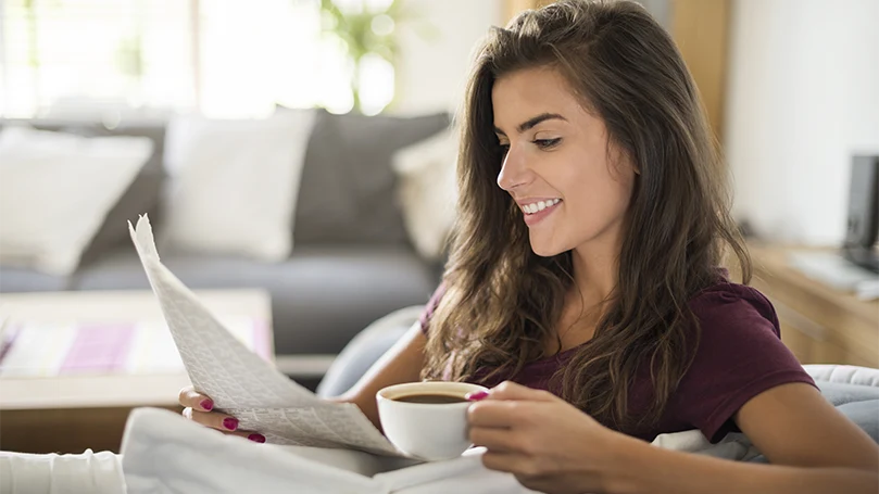 Una imagen de una mujer joven tomando su café.