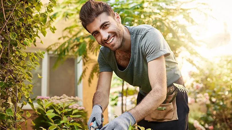 Imagen de un hombre trabajando en el jardín a la luz del día.