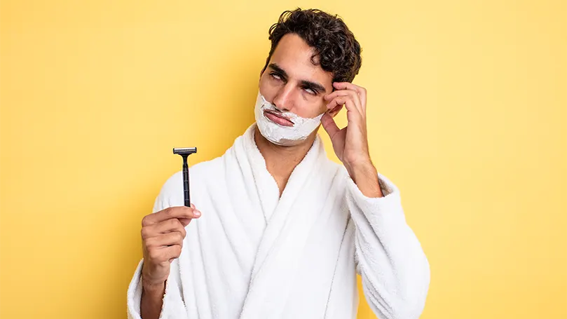 Imagen de un hombre aplicándose espuma de afeitar en la cara.