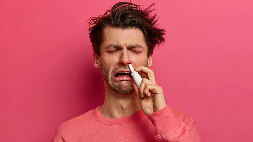 Imagen de un hombre alérgico que utiliza gotas nasales.