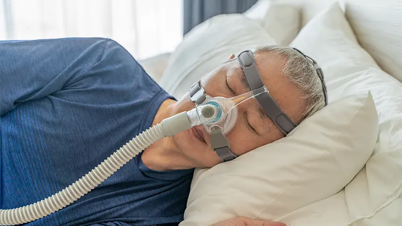 Un hombre mayor durmiendo con mascarilla CPAP