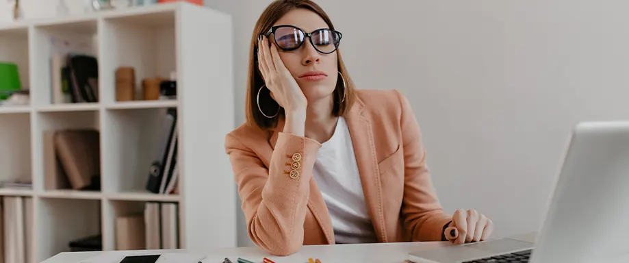 Mujer durmiendo la siesta en el trabajo de escritorio