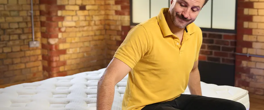 The Sleep Advisors presenter sitting on a luxury mattress