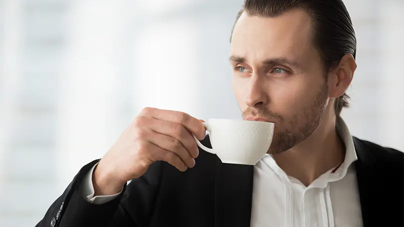 Imagen de un hombre bebiendo café y soñando despierto.