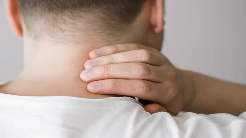 Imagen de un hombre sujetándose el cuello debido a un dolor cervical.