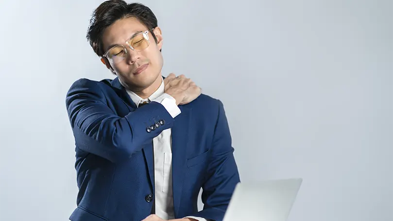 An image of a man in suit suffering from a muscle strain.