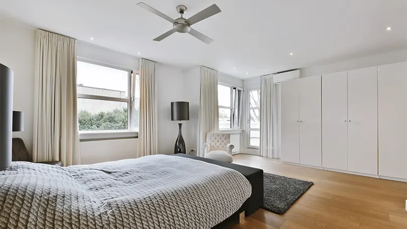 Imagen de un dormitorio minimalista con ventilador en el techo.