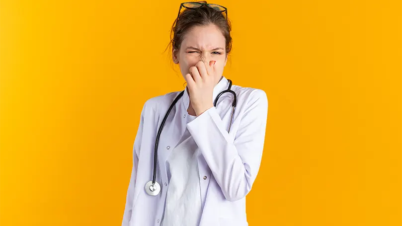 An image of a doctor holding her nose