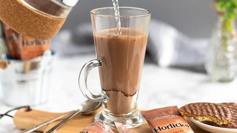 Vertiendo horlicks en un vaso.