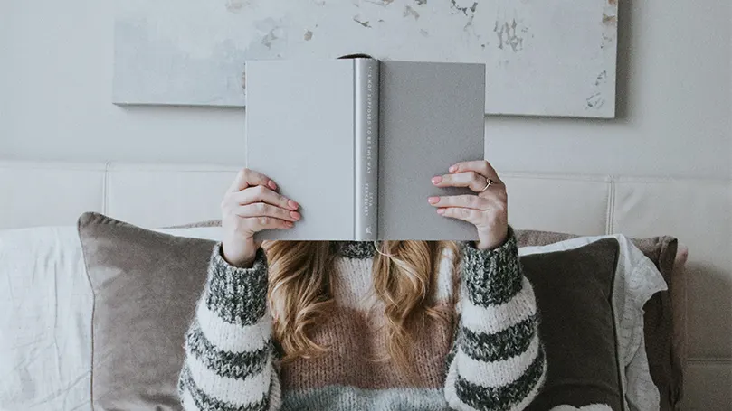 An image of a woman reading a self-help book