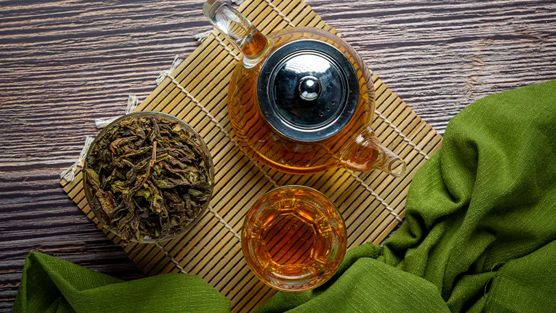 Una imagen de té oolong en una tetera colocada sobre una mesa