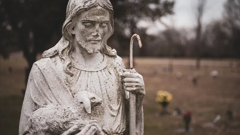 Una imagen de una estatua de un pastor y una figura religiosa