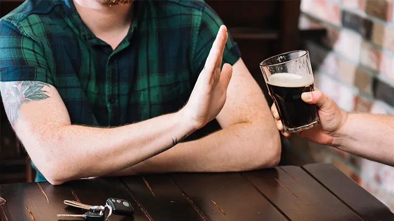 Una imagen de un hombre diciendo no al alcohol.