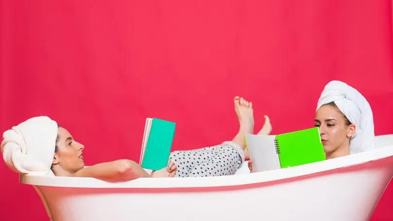 An image of two people reading in a bathtub