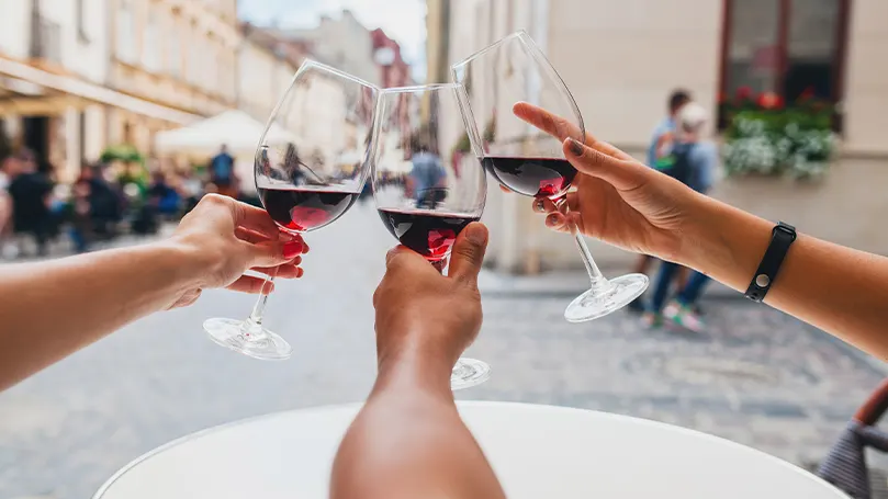 Imagen de tres personas sosteniendo copas de vino.