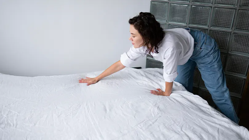 Imagen de una mujer haciendo la cama.