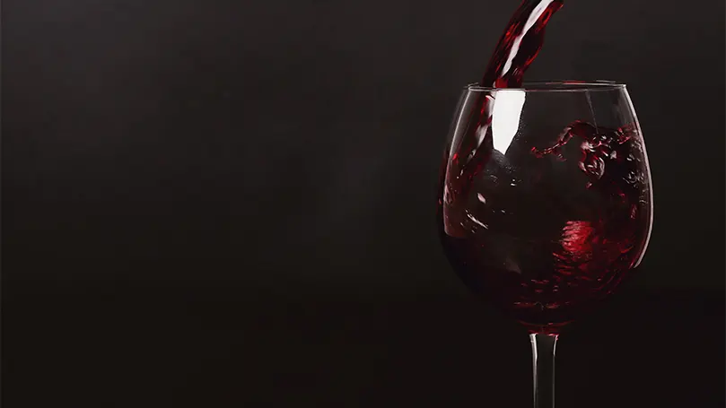 Imagen de vino tinto vertido en un vaso.