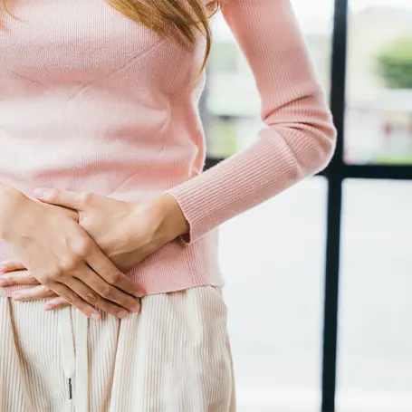 An image of a woman holding her stomach