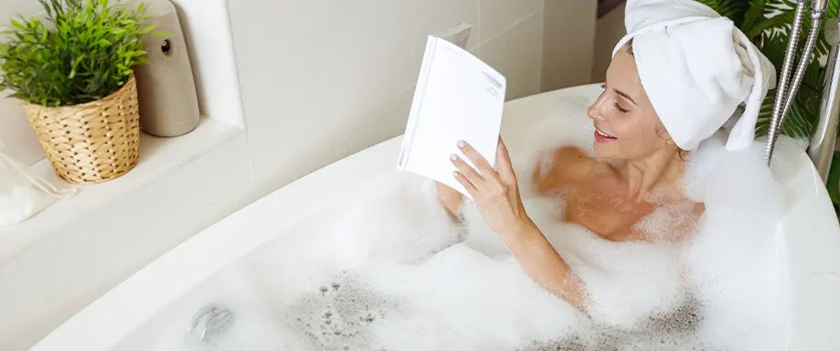 Mujer leyendo un libro en la bañera