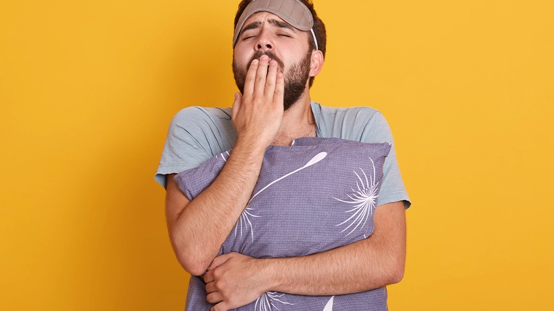 Imagen de un hombre que ha dormido poco y bosteza