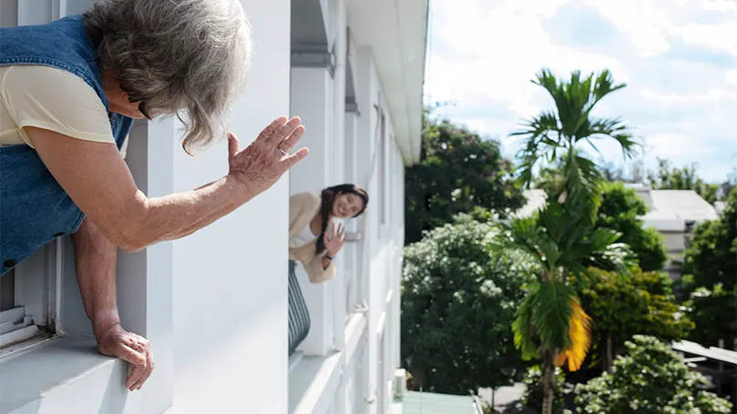 Una imagen de una mujer saludando a su vecino