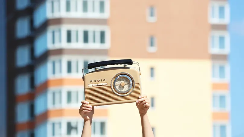 Imagen de una persona con una radio en la mano.