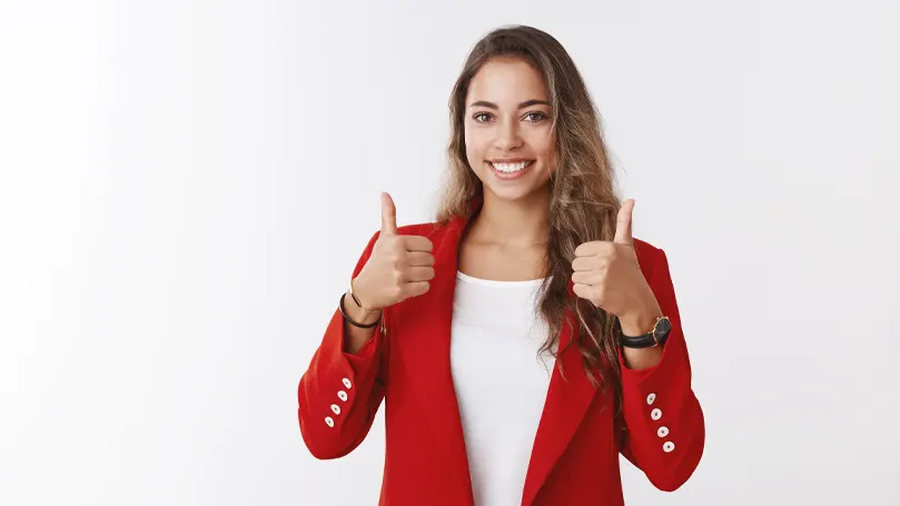 Una imagen de una mujer sonriendo y levantando dos pulgares