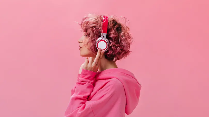 Imagen de una mujer con los auriculares puestos escuchando música