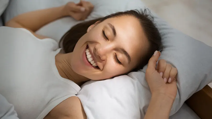 Una mujer riendo mientras duerme.