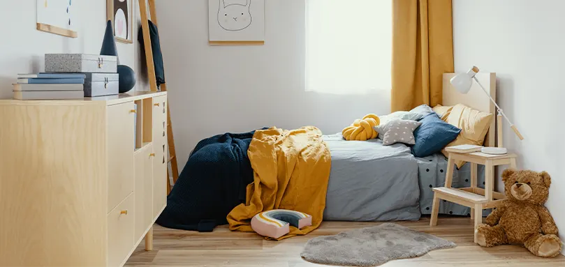 Dormitorio con cama de madera y muebles en azul marino y amarillo.