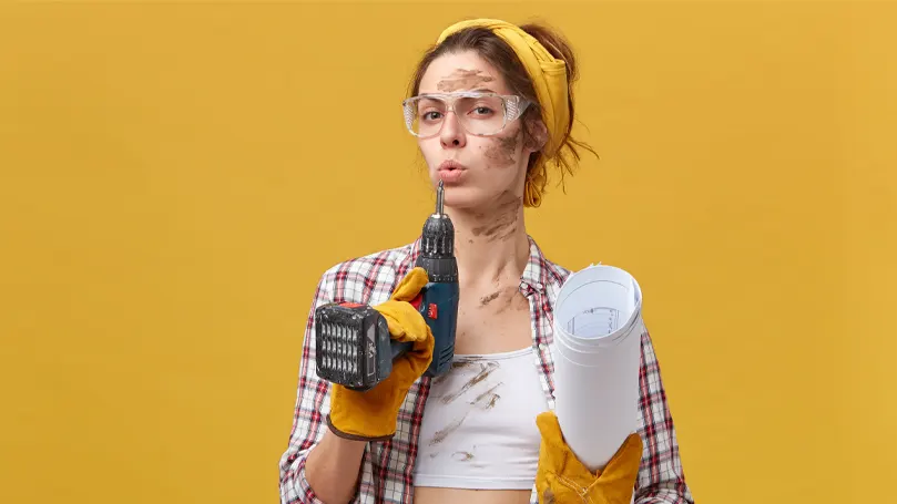 Imagen de una mujer con herramientas recuperando el aliento tras un proyecto de bricolaje.