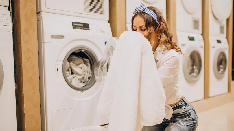 a woman smelling freshly washed sheets