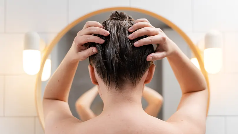 una mujer lavándose el pelo