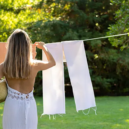 Una mujer cuelga la ropa para que se seque al aire libre