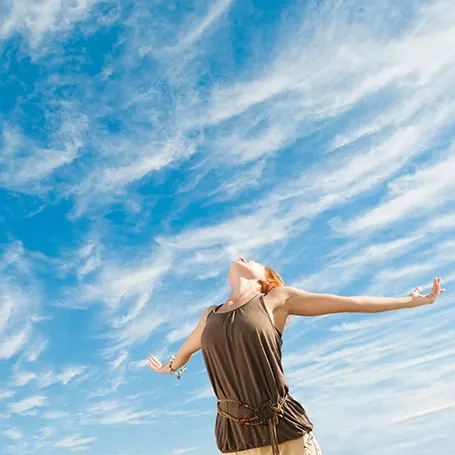 Una imagen de una mujer disfrutando de un cielo despejado.