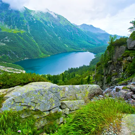 Una imagen de un paisaje con montañas y un lago a lo lejos